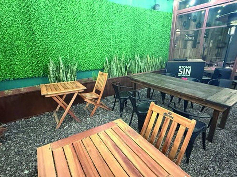 Patio con muro verde y mesa