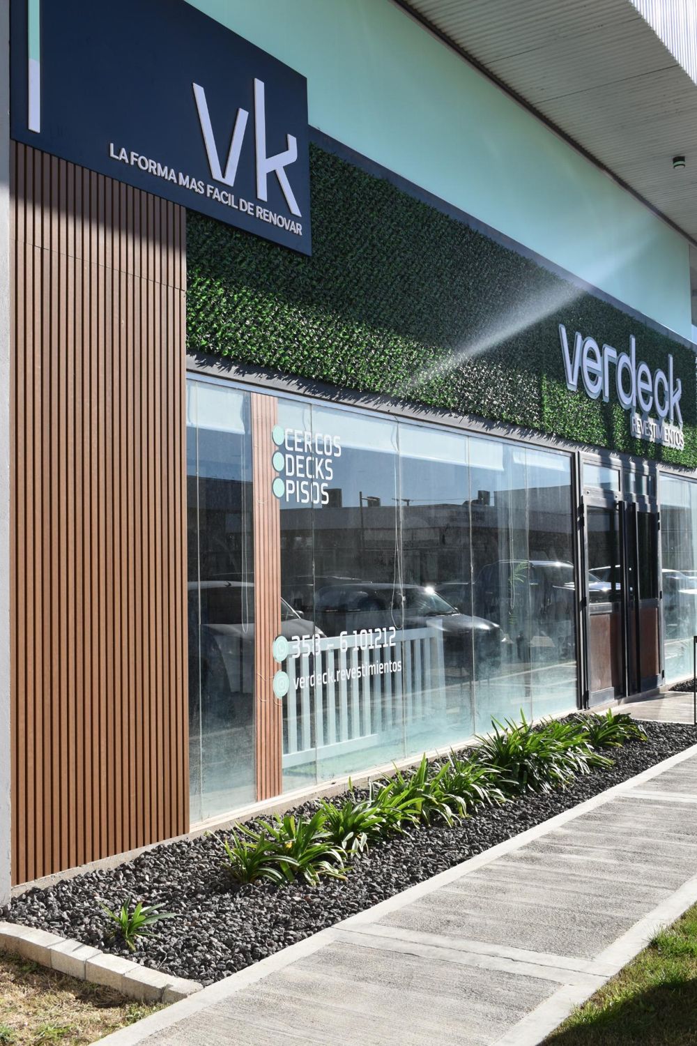 Frente del showroom de Verdeck con revestimiento WPC y muro verde